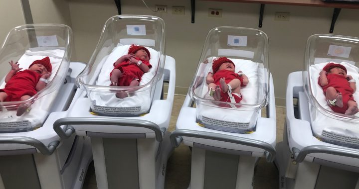 Newborn babies in hospital wear red onesies and hats for american heart month