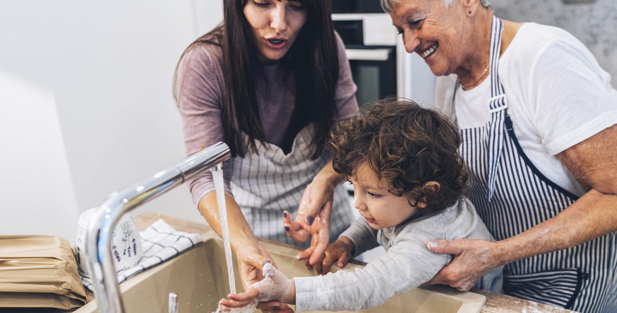 Family washing their hands together at home.