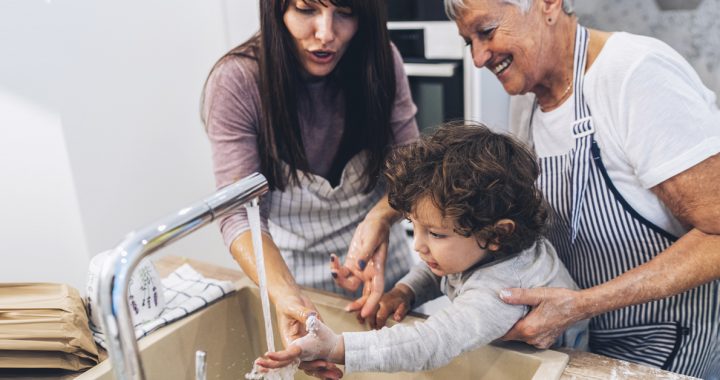 Family washing their hands together at home.