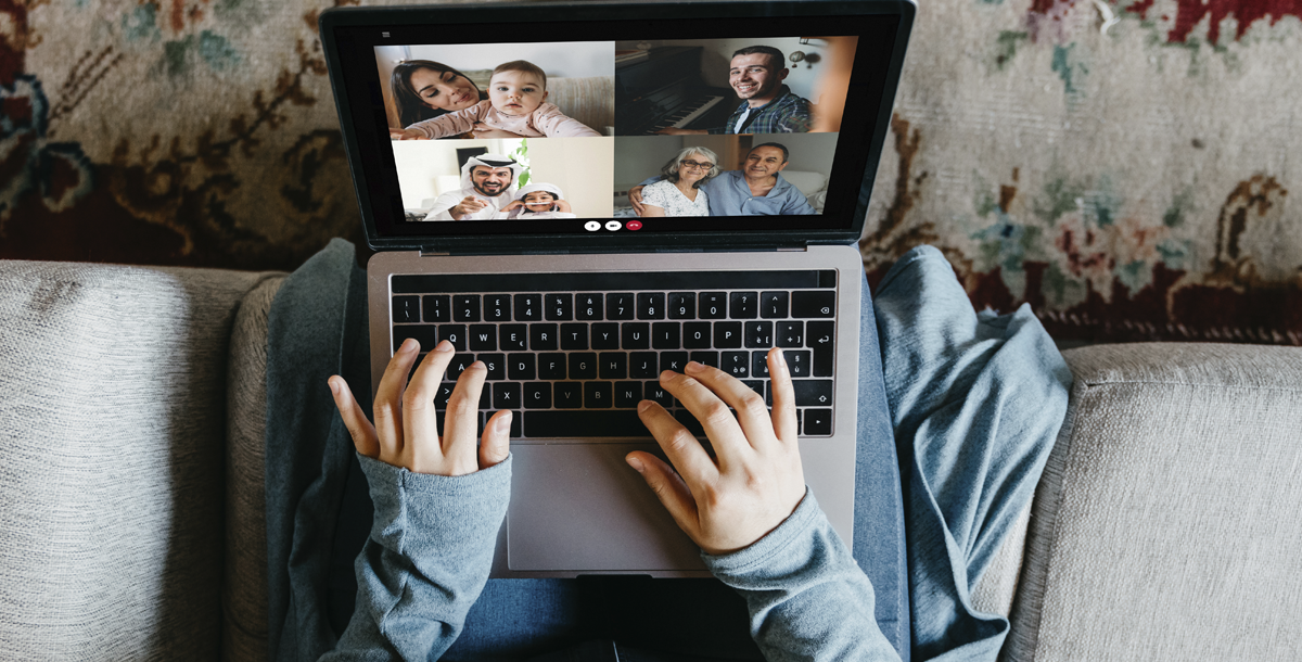 Individual practicing social distancing by video chatting with family at home.