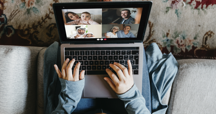 Individual practicing social distancing by video chatting with family at home.