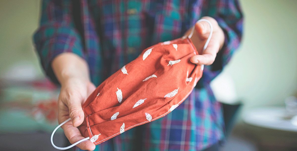 A person holding a homemade cloth face covering