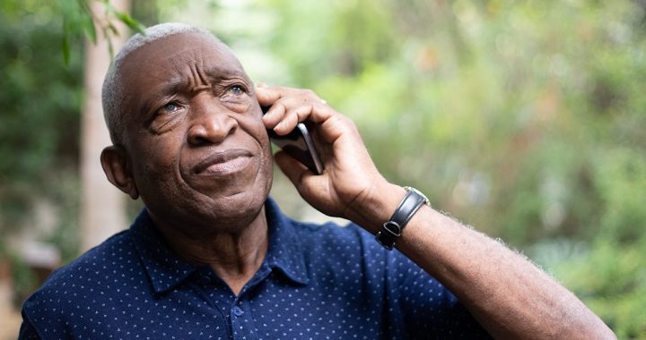 A man on the phone with hospital staff advocating for a loved one