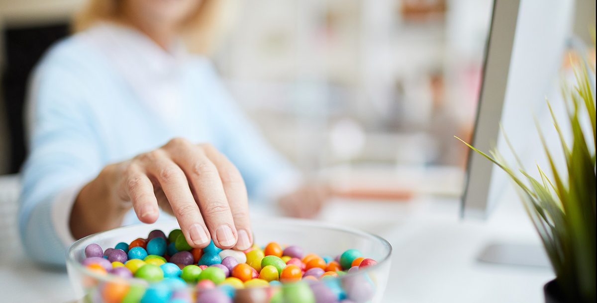 A woman stress snacking candy at home during COVID-19