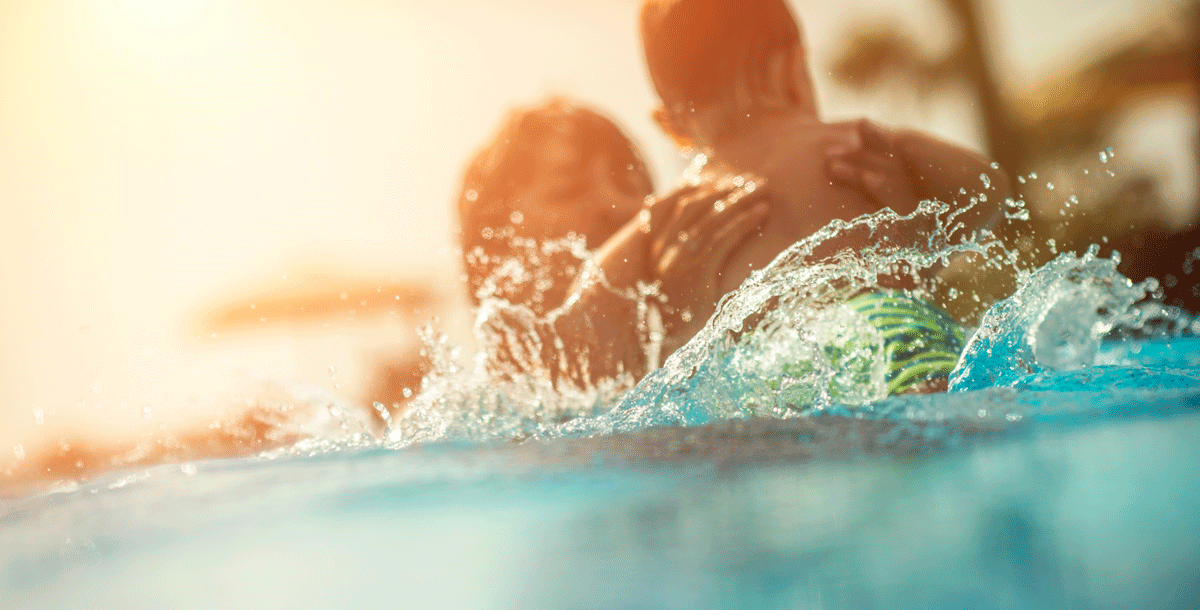 Mother swimming in a pool with her child during COVID-19