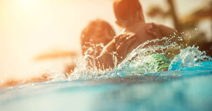 Mother swimming in a pool with her child during COVID-19