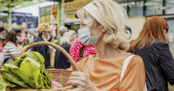 A woman wearing a face mask to a farmers market during COVID-19.