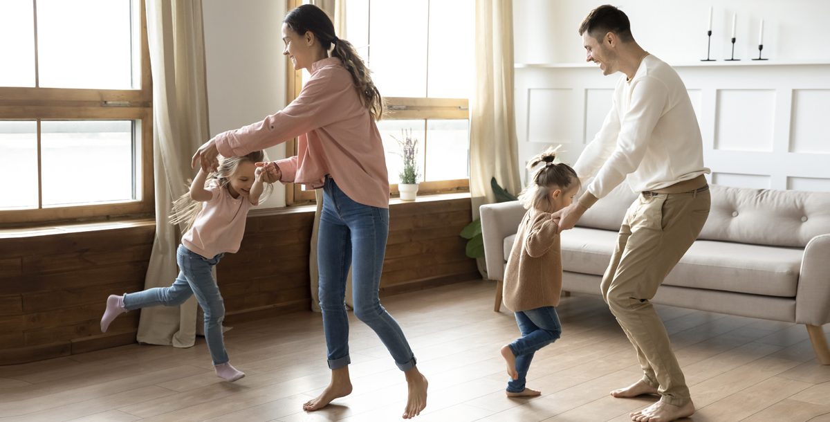 Parents and kids having a dance party together in their living room.