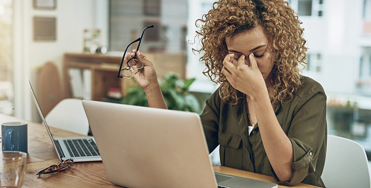 A woman experiencing digital eye strain while working from home.