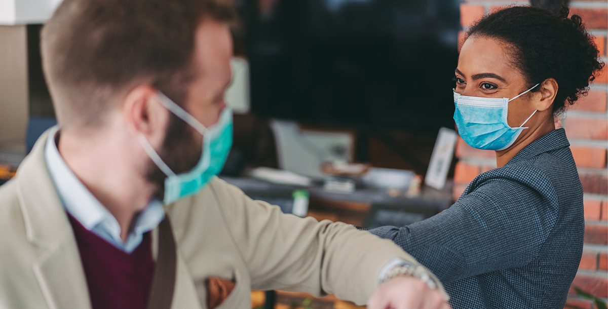 Two people wearing their face masks in public.