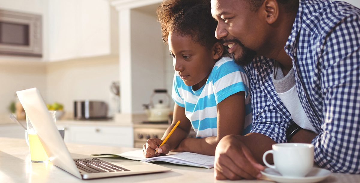 A father helping is daughter with e-learning at home during COVID-19.