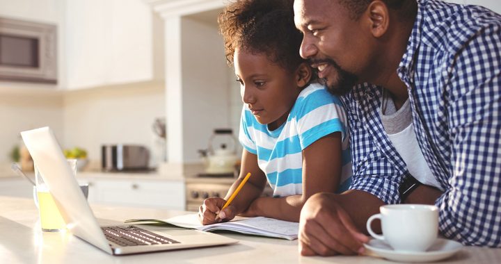 A father helping is daughter with e-learning at home during COVID-19.