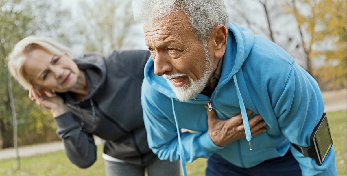 A man experiencing one of the early signs of a heart attack: chest pain.