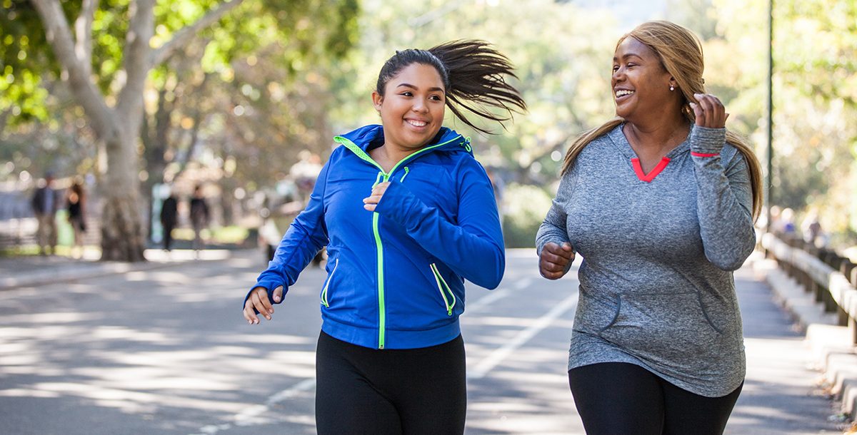 Two women exercising outside.