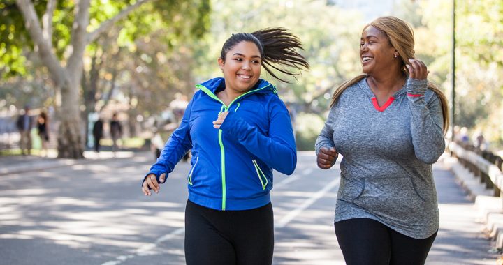 Two women exercising outside.