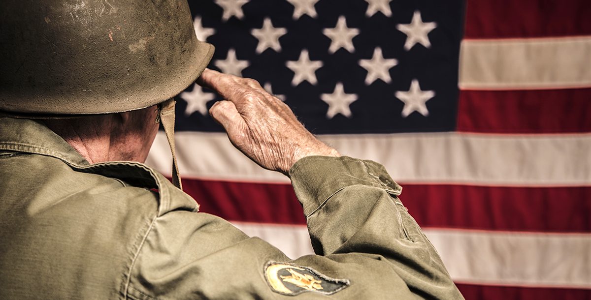 A veteran saluting the American flag.