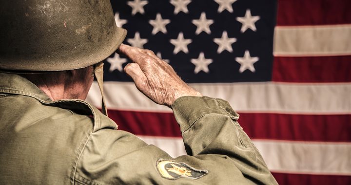 A veteran saluting the American flag.