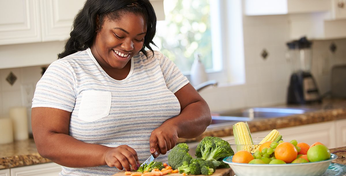 A woman cooking a healthy meal in her kitchen.