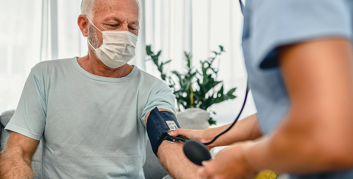 A man getting his blood pressure checked by his primary care provider.