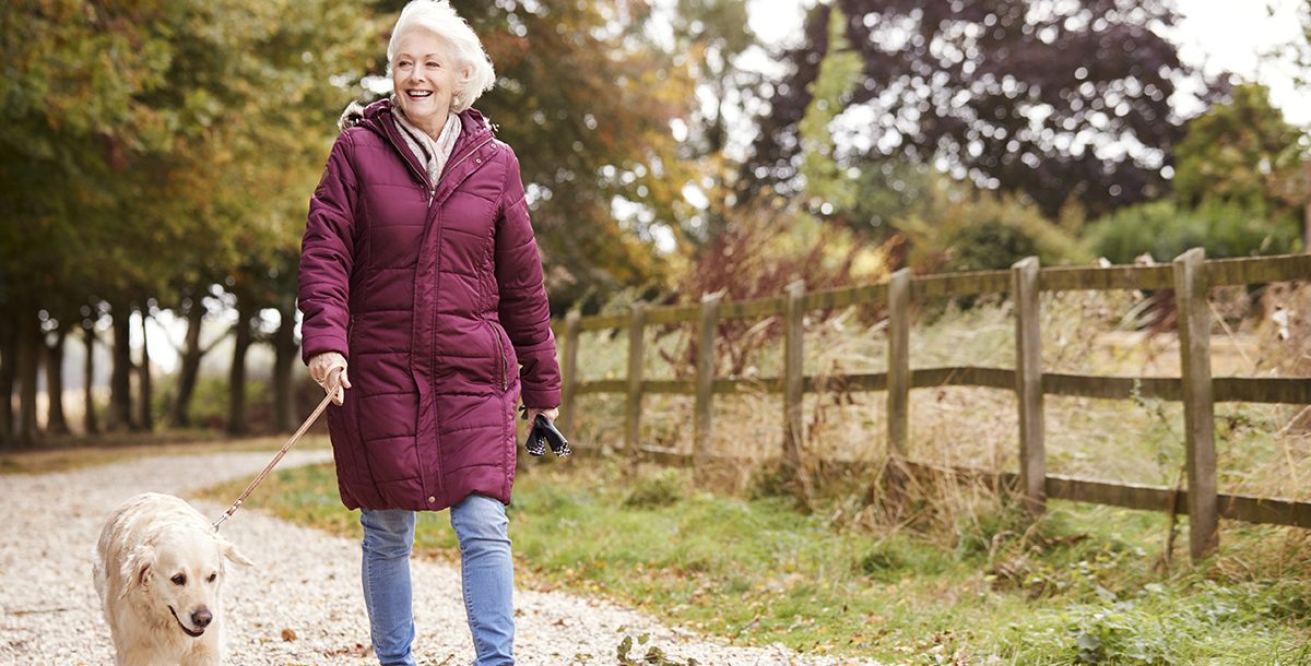 A woman on a walk with her dog.