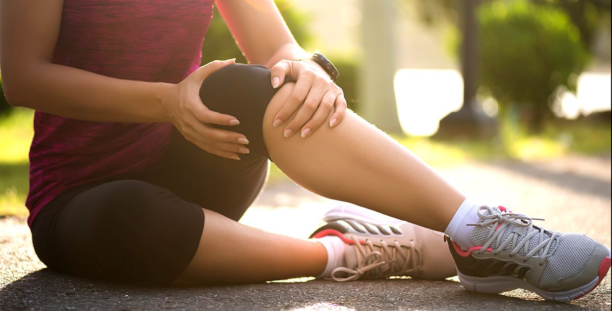 A woman experiencing a knee strain