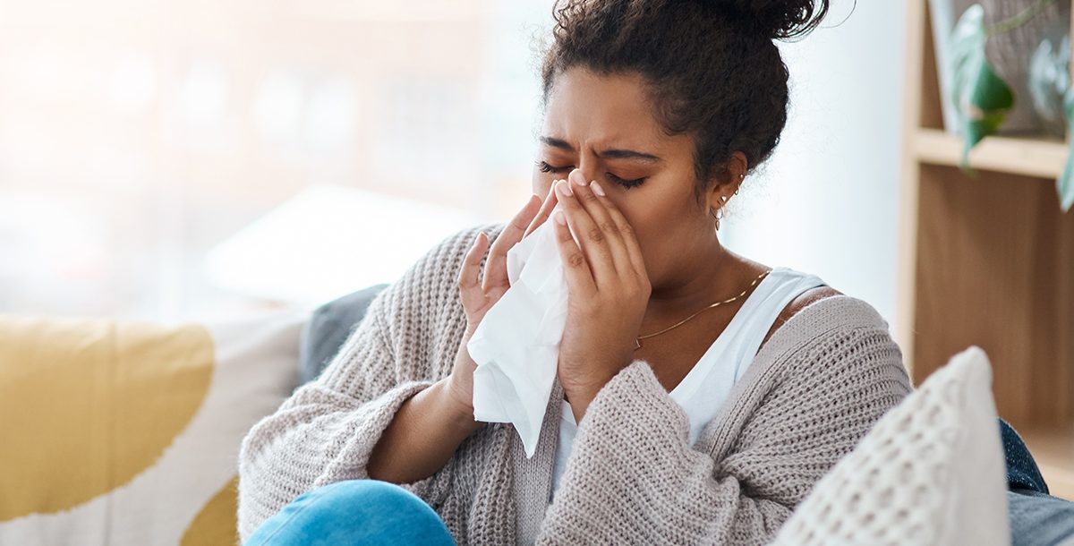 A woman sneezing and blowing her nose.