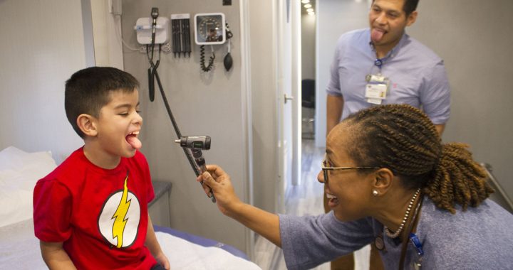 Dr. Young with a pediatric patient prior to COVID-19.