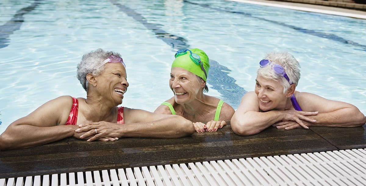 Three senior friends swimming together.