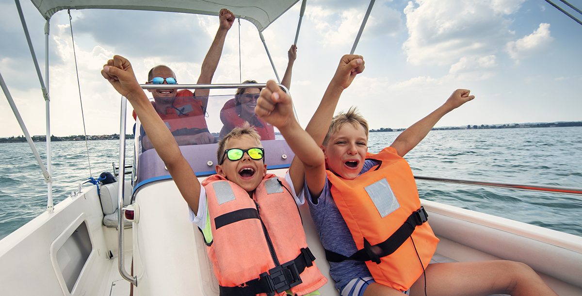 Two kids on a boat ride with their parents.