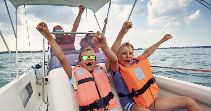 Two kids on a boat ride with their parents.