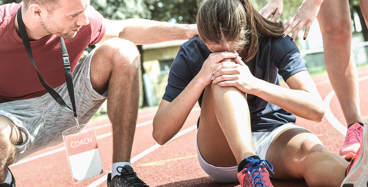 A woman experiencing a common summer injury from running.