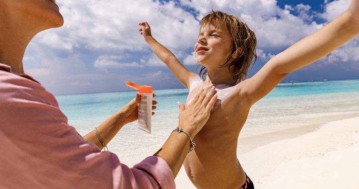 A parent applying sunscreen to their child.