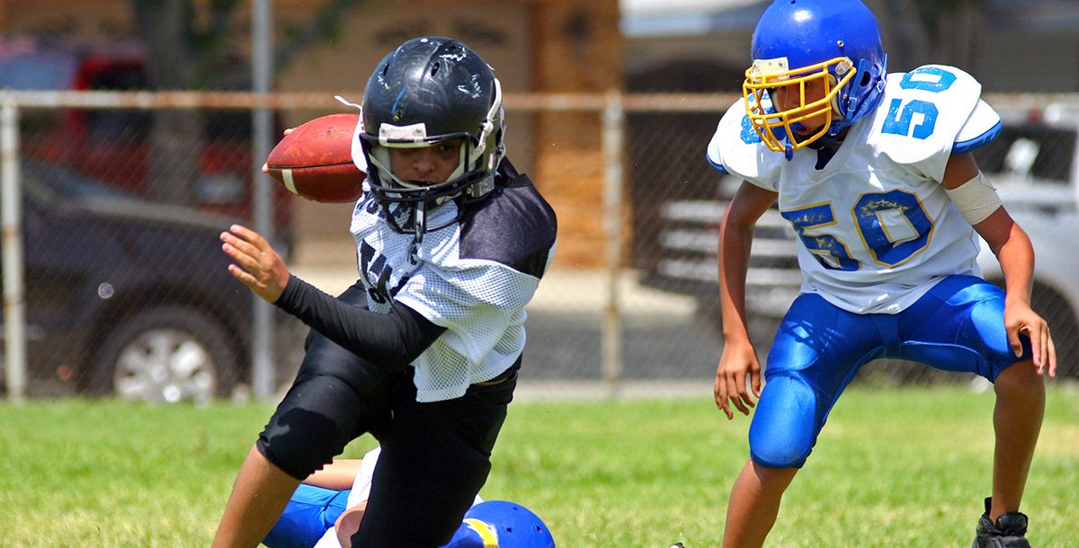 Two kids playing football.