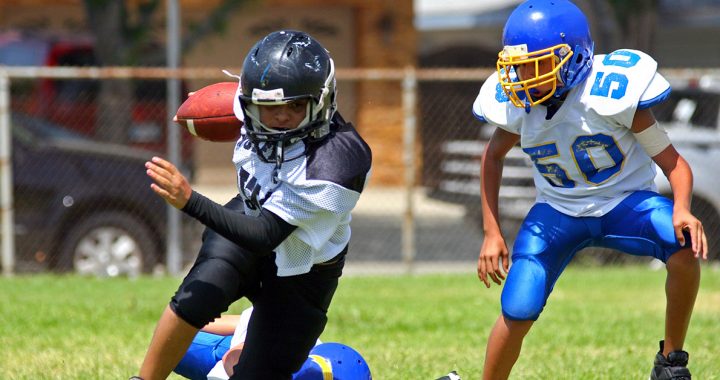 Two kids playing football.