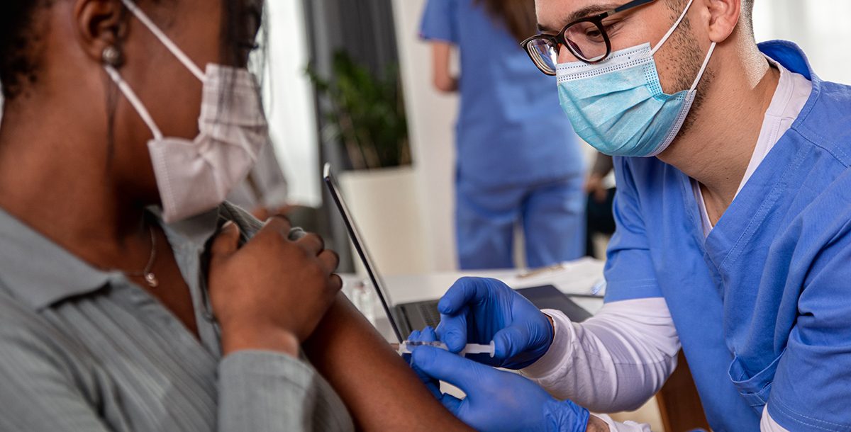 A patient getting their flu and COVID-19 vaccines.