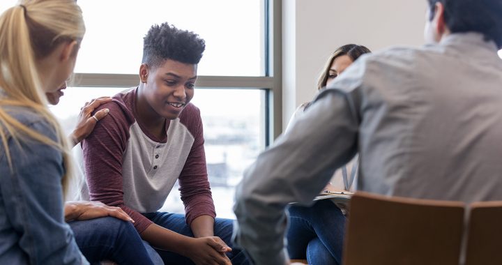 A young man talking about his mental health with a group.