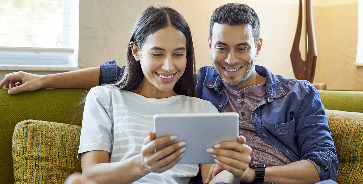 A happy couple reading the news.