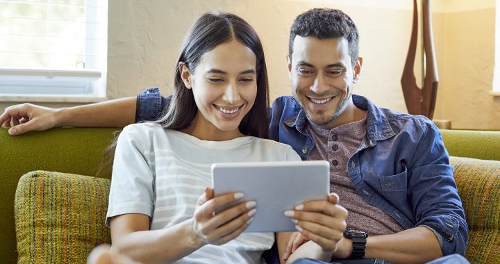 A happy couple reading the news.