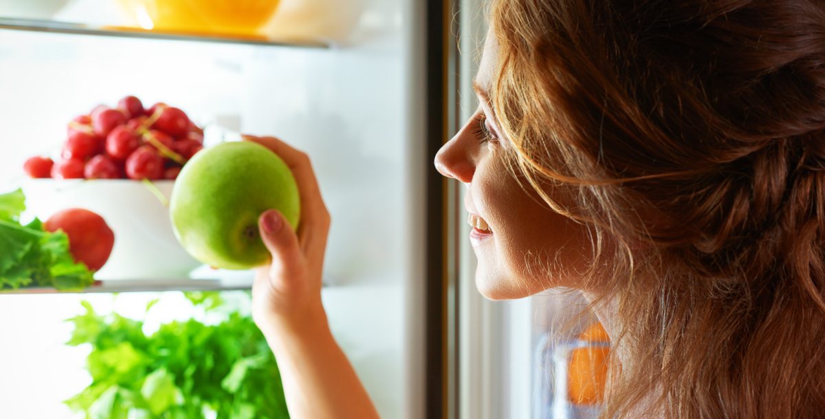 A teen eating some fruit.